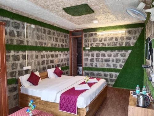 1 dormitorio con cama y pared verde en Cholai Resorts & Hotels en Yercaud