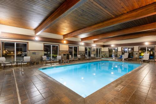 a large swimming pool in a hotel with tables and chairs at Holiday Inn Express Vancouver North, an IHG Hotel in Vancouver