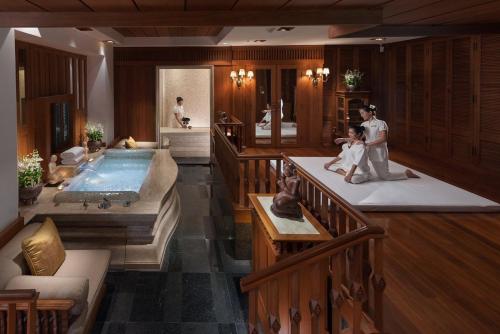 una sala de estar con piscina y un hombre y un niño en una bañera en Mandarin Oriental, Bangkok, en Bangkok