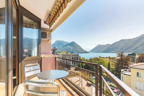 d'un balcon avec une table et des chaises et une vue sur l'eau. dans l'établissement Hotel Delfino Lugano, à Lugano