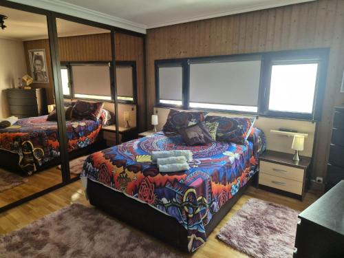 a bedroom with a bed and a mirror at La Torre, vistas a la bahía in Laredo