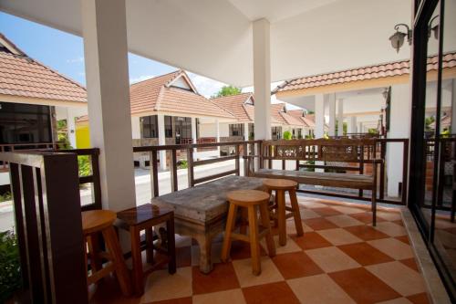 patio con mesa y sillas en el balcón en หาดทรายขาวรีสอร์ท en Bang Saphan