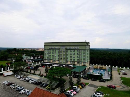 um grande edifício verde com carros estacionados num parque de estacionamento em Savanna Hill Resort em Johor Bahru