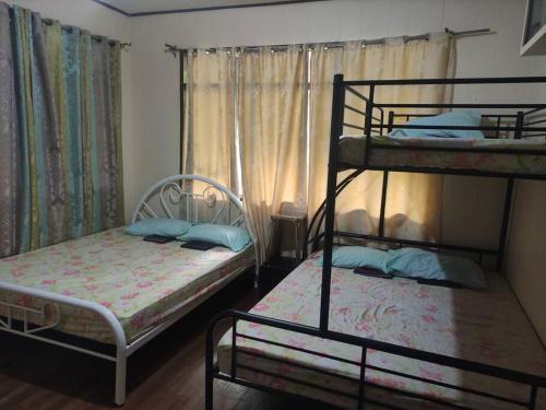 1 dormitorio con 2 literas y ventana en Big and Spacious House near 7-11, en Bacolod