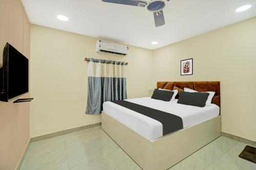 a bedroom with a bed and a flat screen tv at Super OYO Hotel O The Rhino Inn in Kamakhya