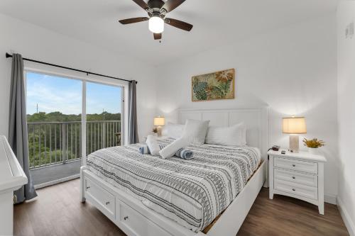 um quarto branco com uma cama e uma janela em 2BR condo minutes to Disney Springs em Orlando