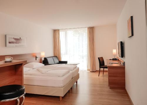 sala de estar con sofá blanco y mesa en Fairmotel Dornbirn, en Dornbirn