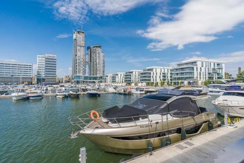 ein Boot liegt in einem Yachthafen mit anderen Booten vor Anker in der Unterkunft Apartament Faltom 26 Yacht Park z tarasem in Gdynia