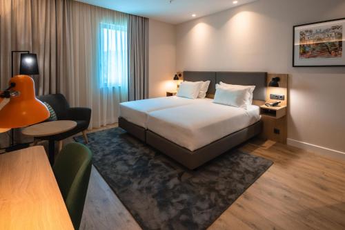 Un pat sau paturi într-o cameră la Holiday Inn Braga, an IHG Hotel