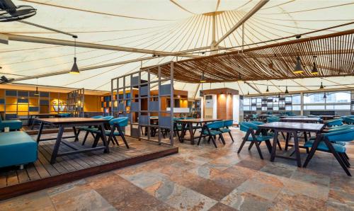 un restaurante con mesas y sillas en una habitación en Treebo Blue Moon en Gandhinagar