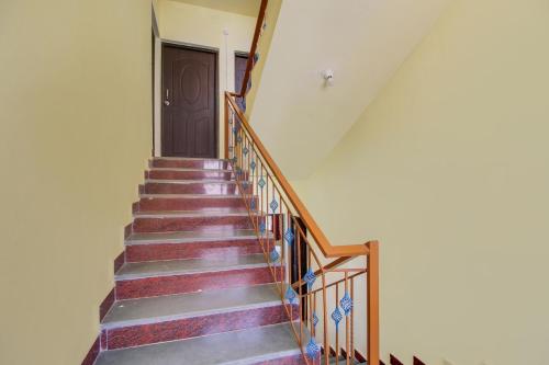 escalera con puerta de madera y escalera en SPOT ON SR Dream Home en Saligao