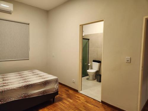 um quarto com uma cama e uma casa de banho com um WC em Casa contemporânea à beira do rio Paraná-VLC Stays em Três Lagoas