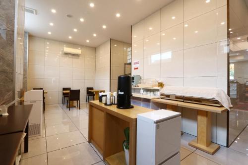 a kitchen with white walls and a counter in a room at ビジネスホテル 山手INN in Iidamachi