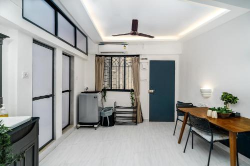 uma sala de estar com uma mesa e uma sala de jantar em Calisto 2BHK Khar W by The Bombay Home Company em Mumbai