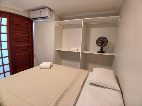 um quarto com uma cama, prateleiras e uma ventoinha em Iracema Residence by Escala Imóveis em Fortaleza