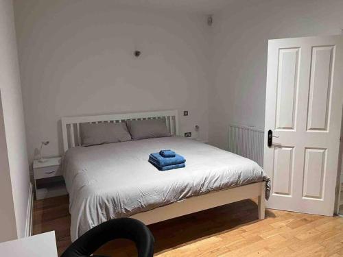 Un dormitorio con una cama con una toalla azul. en 2 bed garden flat West Dulwich FREE STREET PARKING en Londres