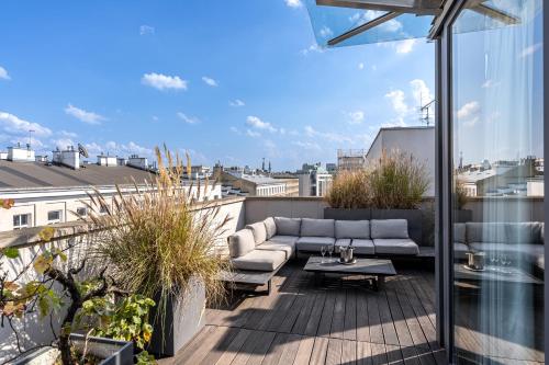 a patio with a couch and a table on a balcony at H15 Boutique Hotel, Warsaw, a Member of Design Hotels in Warsaw