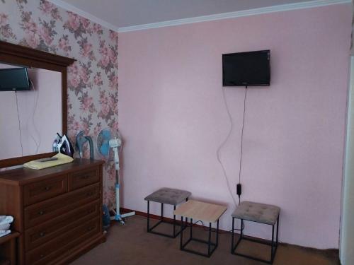 a room with two stools and a television on a wall at 2-х комнатная квартира in Korostenʼ