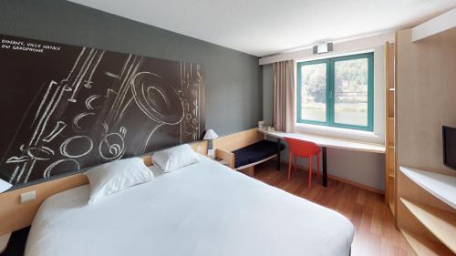 um quarto de hotel com uma cama e uma janela em ibis Dinant Centre em Dinant