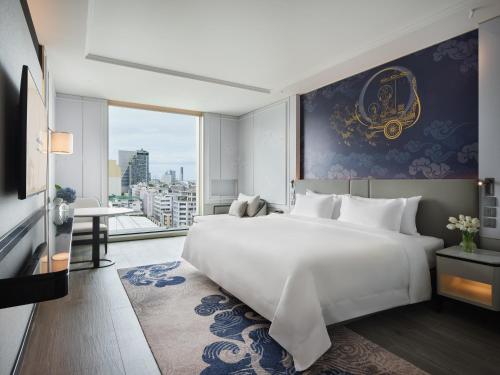 1 dormitorio con 1 cama blanca grande y ventana grande en Grande Centre Point Surawong Bangkok, en Bangkok