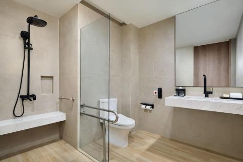 y baño con ducha, aseo y lavamanos. en Fairfield by Marriott Jakarta Soekarno-Hatta Airport en Tangerang