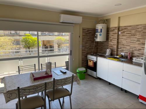 a kitchen with a table and chairs in a kitchen at Caracolas Departamentos in San Clemente del Tuyú