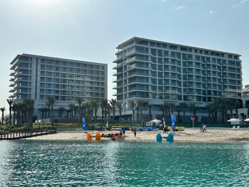 widok na plażę z dwoma wysokimi budynkami w obiekcie Address Beach Resort Residence Bahrain w mieście Manama