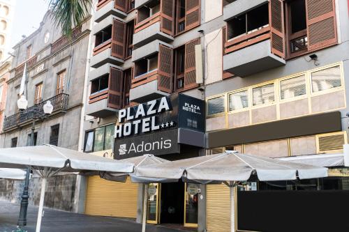 un hotel con sombrillas frente a un edificio en Hotel Adonis Plaza, en Santa Cruz de Tenerife