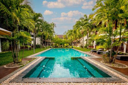 una piscina en un complejo con palmeras en Green Park Boutique Hotel en Vientián