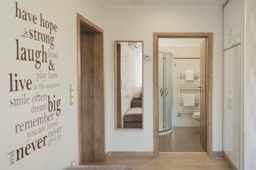 Cette chambre comprend un miroir et une salle de bains. dans l'établissement Harmony Apartments Sárvár, à Sárvár