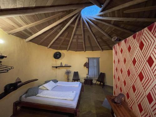 een slaapkamer met een bed en een houten plafond bij Cantos da Mata in Chapada dos Guimarães