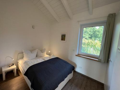 1 dormitorio con cama y ventana en Ferienhaus Auszeit mit Sauna en Schwarz