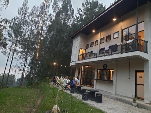 pessoas sentadas num banco do lado de fora de um edifício em Bromo Dormitory & Camp em Bromo