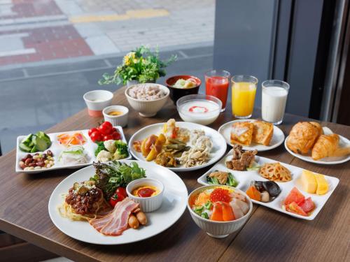 una mesa de madera con platos de comida y bebida en Susukino Granbell Hotel en Sapporo