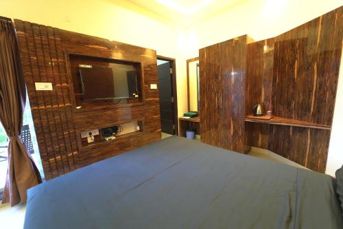 1 dormitorio con 1 cama y TV en la pared en Melody Inn Luxury Home Stay, en Yercaud