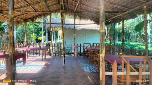 un pabellón en un restaurante con mesas y sillas en Tranquil Bambusic Bliss, en Kāziranga