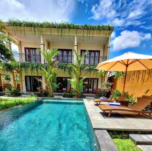 une maison avec une piscine et un parasol dans l'établissement tiny's house, à Ubud