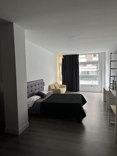 ein Schlafzimmer mit einem Bett, einem Stuhl und einem Fenster in der Unterkunft Apartamentos R&K 26B in Bilbao