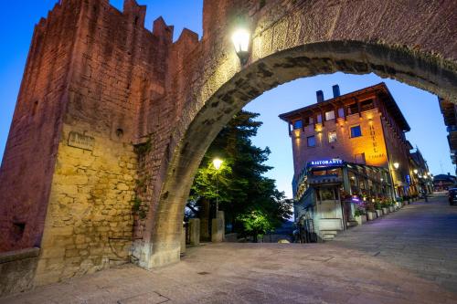 Un arco sobre una calle en una ciudad por la noche en Hotel Cesare en San Marino