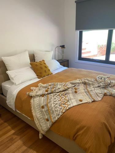 uma cama com um cobertor e almofadas em High Country Retreat em Jamieson