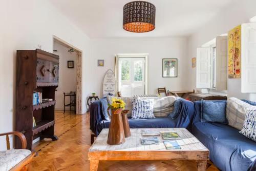 sala de estar con sofá azul y mesa en Lanui Vintage Guest House en Sintra