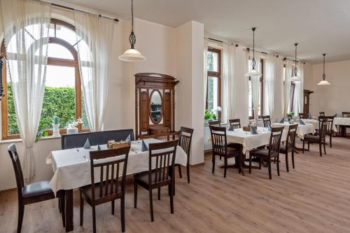 un restaurant avec des tables blanches, des chaises et des fenêtres dans l'établissement Hotel Reichskrone, à Heidenau