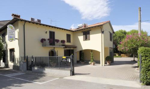 un edificio con cancello in un parcheggio di La Spiga Affittacamere a Campi Bisenzio