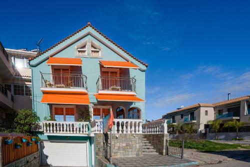 una casa azul y naranja con un garaje blanco en Belleza Villa, en Lixouri