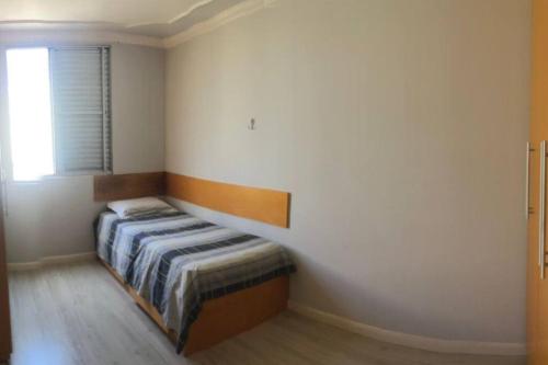 een slaapkamer met een bed in een kamer met een raam bij Apartamento completo, com excelente localização in Americana