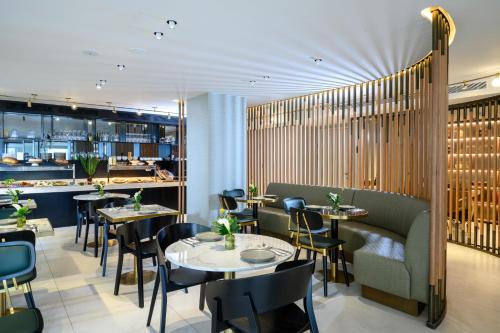 un restaurant avec des tables et des chaises ainsi qu'un bar dans l'établissement Jewel TLV Hotel, à Tel Aviv