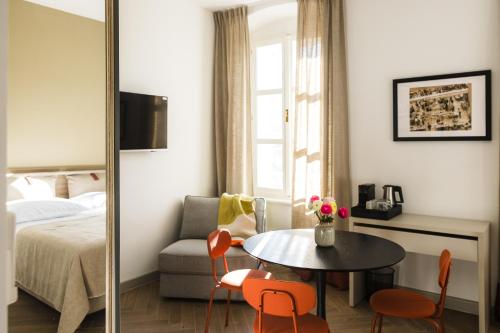 um quarto com uma cama, uma mesa e cadeiras em PIAC Luxury Suites em Split