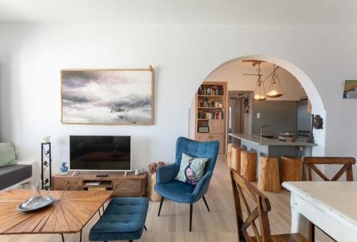 un salon avec une chaise bleue et une table dans l'établissement Blue Moon Mykonos Homes, à Mykonos