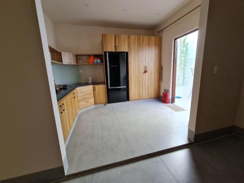 a kitchen with wooden cabinets and a black refrigerator at Nhà Mer – Homestay đảo Phú Quý in Cu Lao Thu