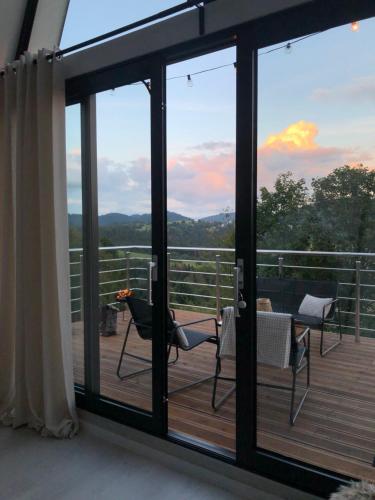 een balkon met glazen schuifdeuren en uitzicht op de bergen bij Áčko in Oščadnica